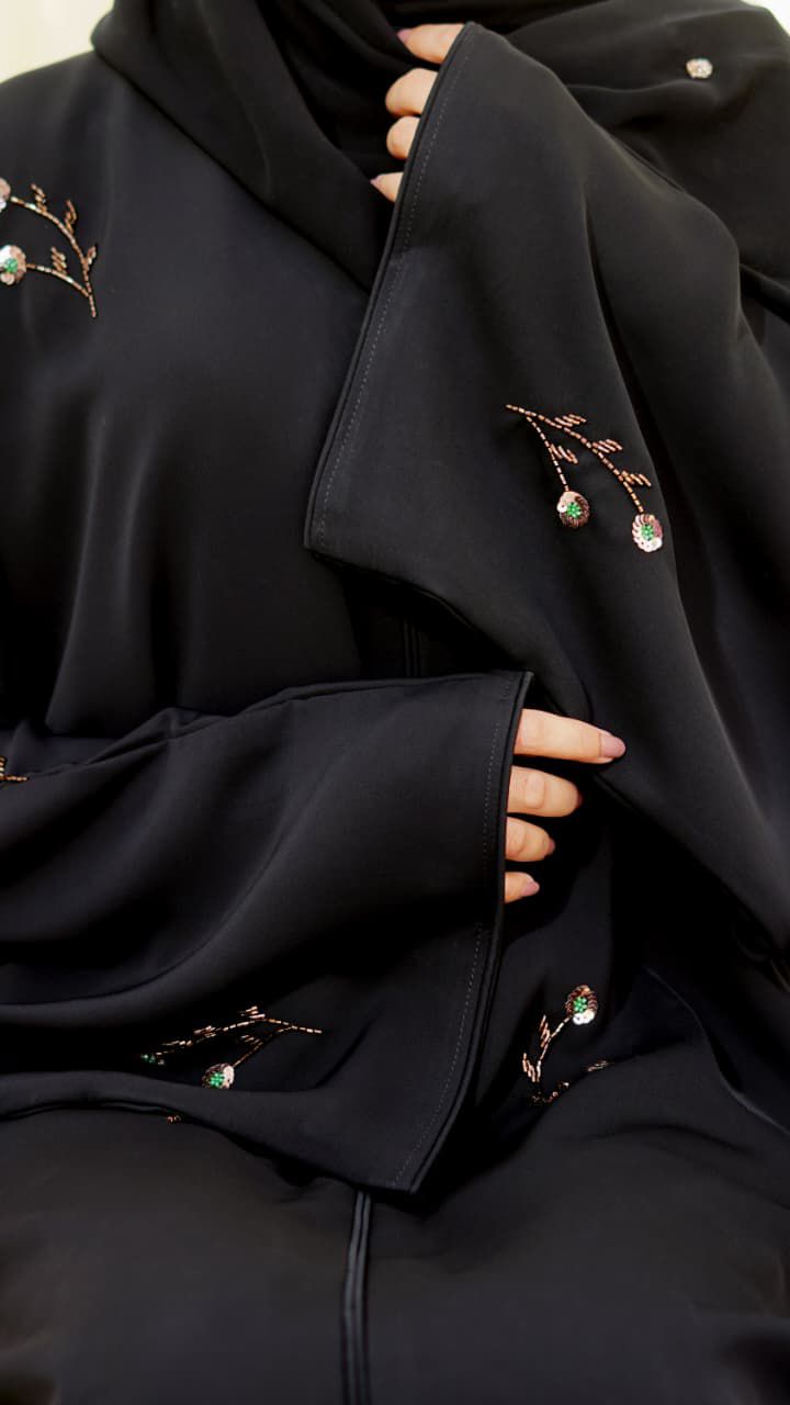 Black Nada fabric abaya with a soft, flowing drape, featuring delicate floral embroidery and subtle bead details